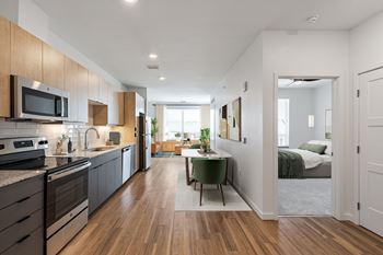 Light wood upper cabinets with charcoal lower cabinets & white ceramic backsplash
